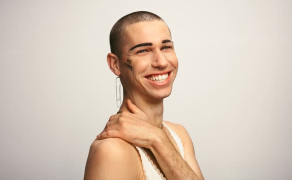 Gender fluid man smiling on white background